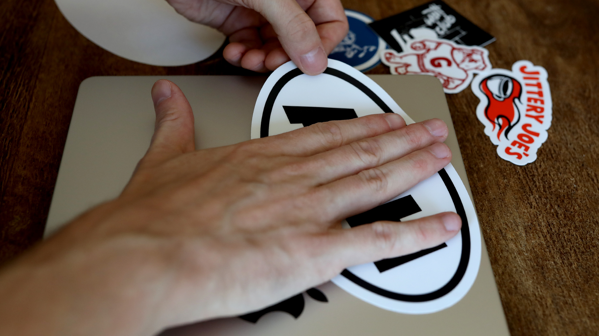 Sticker fest auf den Laptop aufkleben