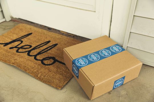 Caja kraft entregada con cinta azul personalizada.