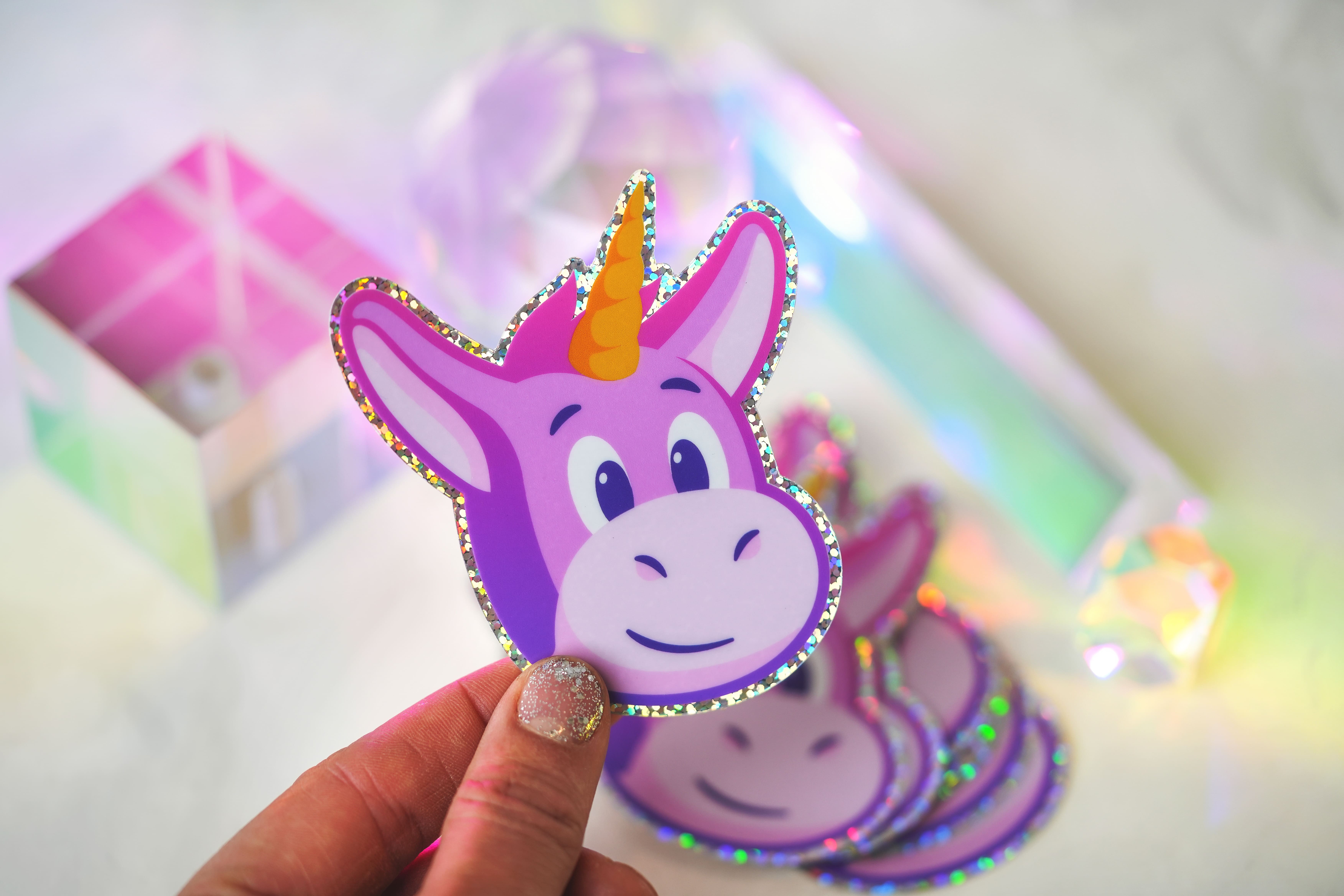 Glitter die-cut sticker of a pink unicorn version of the Sticker Mule mascot, Herman.