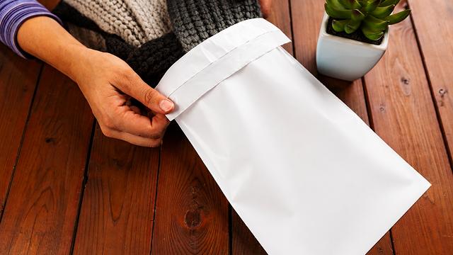 Blank white polymailer containing wool items.